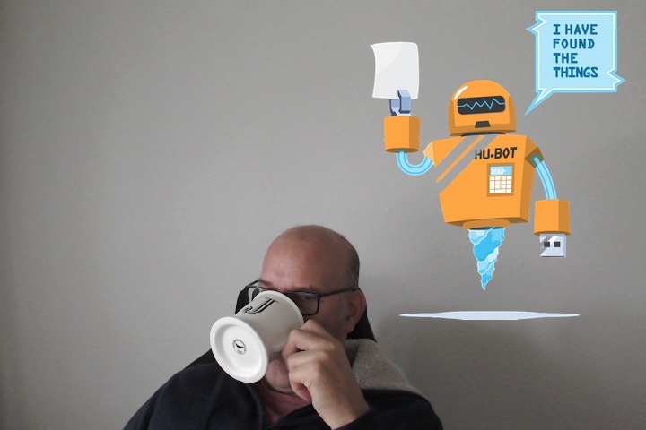 Photo of me sipping coffee from a white cup, and Hubot with a chat bubble that says, I have found the things